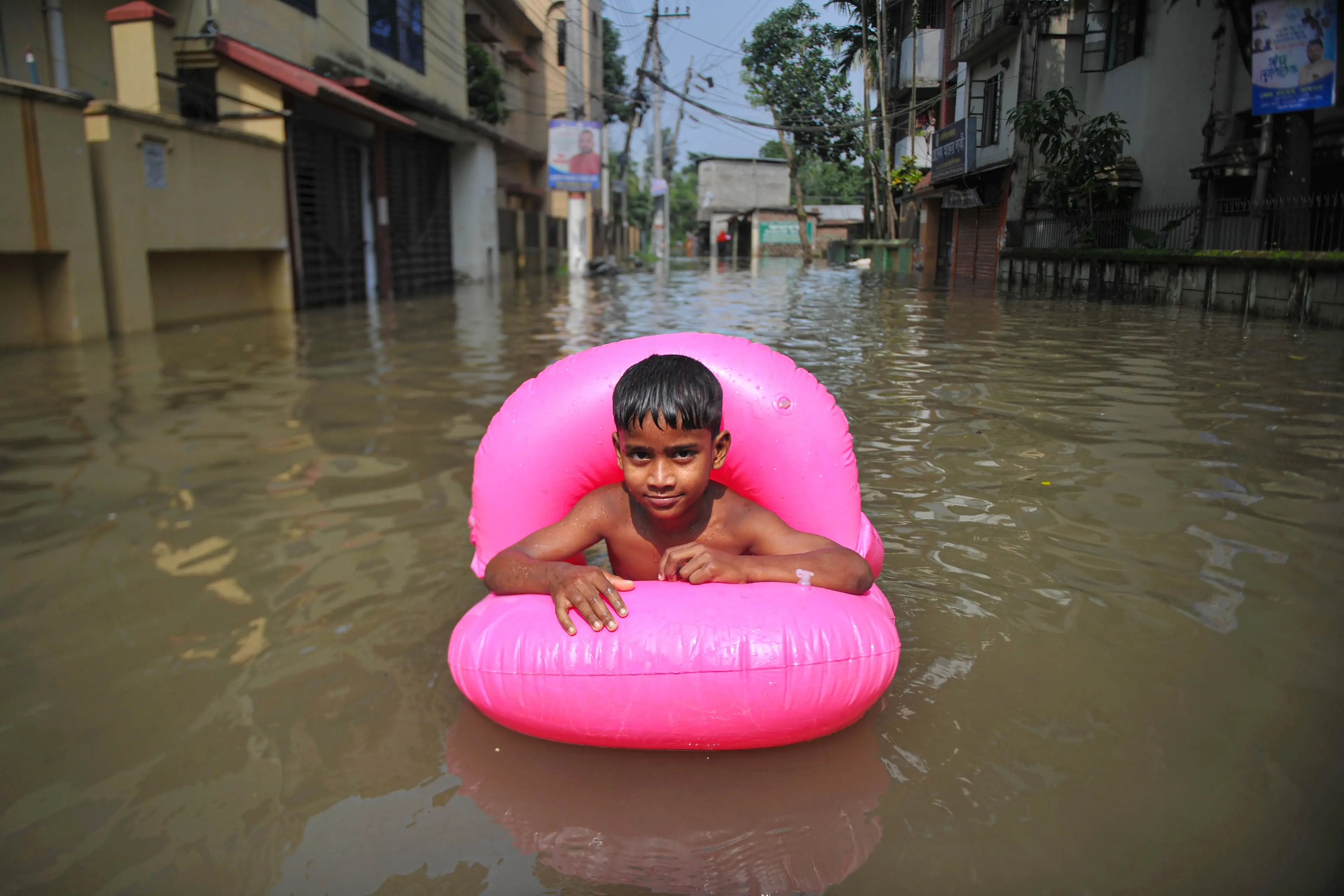 Bangladesh, Sylhet, 19 maggio, 2022 : Un bambino nuota con un salvagente, in una strada sommersa d'acqua nella zona residenziale Uposhahar di Sylhet, in Bangladesh. Mentre l'alluvione peggiora nella città di Sylhet, molte persone delle aree residenziali di Uposhahar lasciano le loro case per un posto sicuro. Foto © Rafayat Haque Khan/Avalon/Sintesi Sylhet, Bangladesh, May 19, 2022 - A kid is swimming in a submerged road in the Uposhahar Residential area of Sylhet, Bangladesh. As the flood worsens in Sylhet city, many people of Uposhahar Residential areas leave their homes for a safe place.