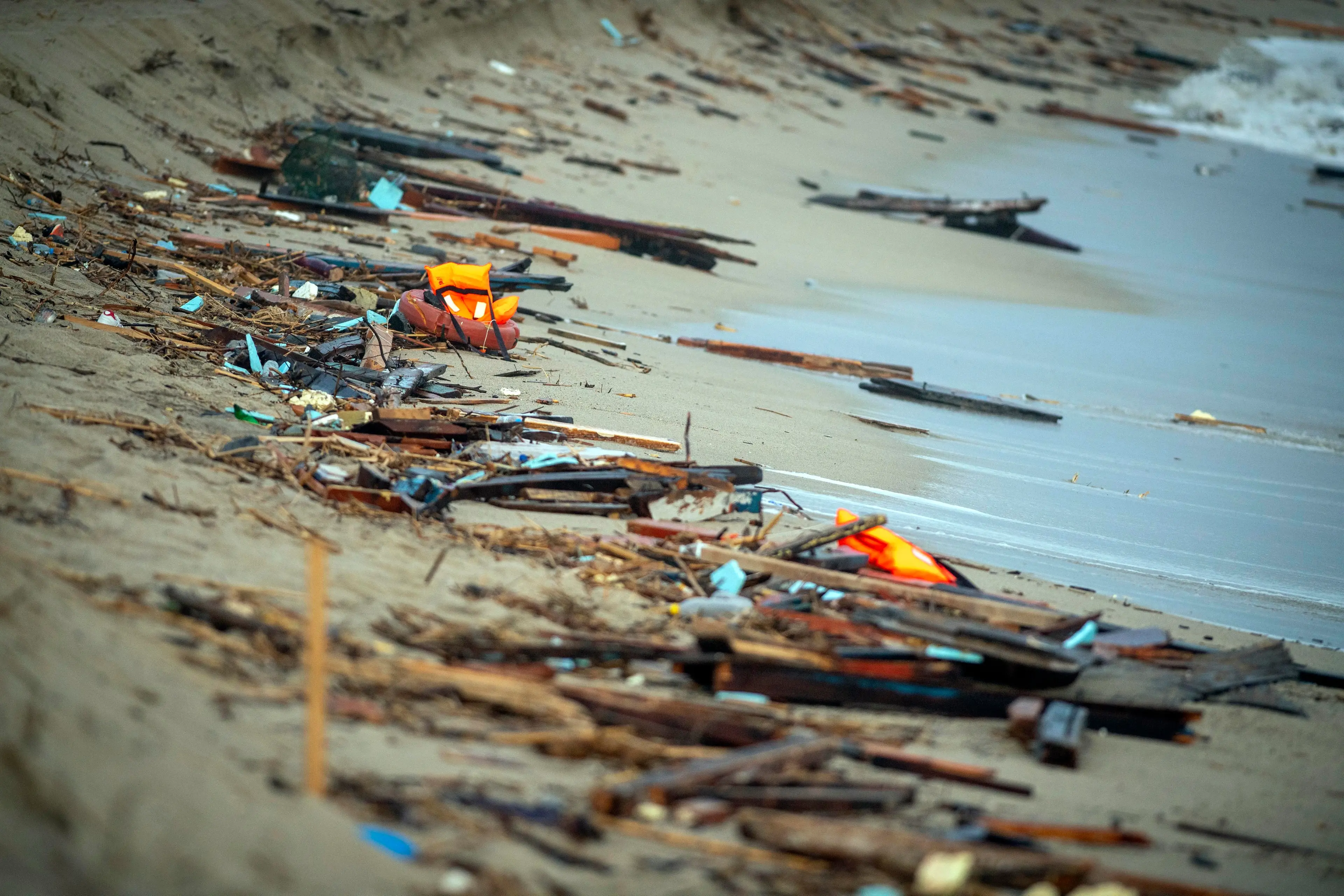 Calabria, spiaggia di Steccato di Cutro (Crotone), 26 febbraio, 2023 : I resti di una barca sono a riva a seguito di un naufragio, nella spiaggia di Steccato di Cutro, provincia di Crotone. Le autorita' italiane hanno recuperato almeno 40 corpi sulla spiaggia e nel mare vicino a Crotone, dopo che un barcone che trasportava migranti è affondato nel mare mosso vicino alla costa. Una quarantina di persone sono sopravvissute al naufragio, hanno aggiunto i vigili del fuoco italiani. Le autorita' temono che il bilancio delle vittime salira', mentre i soccorritori cercano sopravvissuti. Foto di © Avalon/Sintesi Debris wash ashore following a shipwreck, at a beach near Cutro, Crotone province, southern Italy, 26 February 2023. Italian authorities recovered at least 40 bodies on the beach and in the sea near Crotone, in the southern Italian region of Calabria, after a boat carrying migrants sank in rough seas near the coast. About forty people survived the accident, Italian firefighters added. Authorities fear the death toll will climb as rescuers look for survivors. 26 Feb 2023