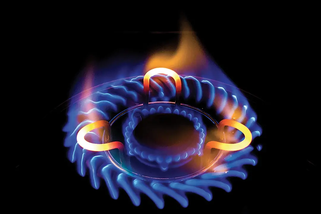 A closeup shot of a beautiful blue flame in a gas stove